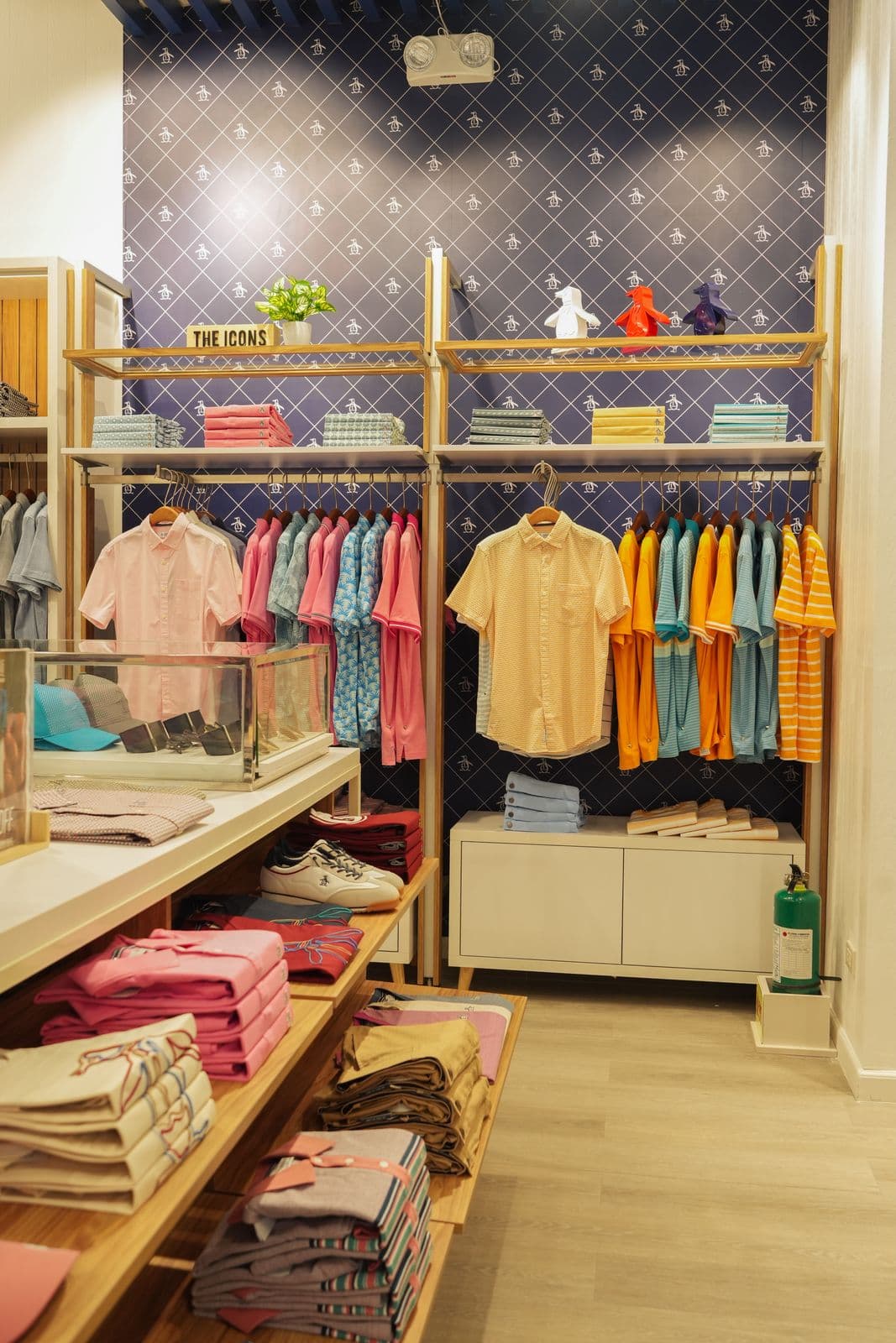 Clothing display wall with custom timber and brass shelving at Original Penguin