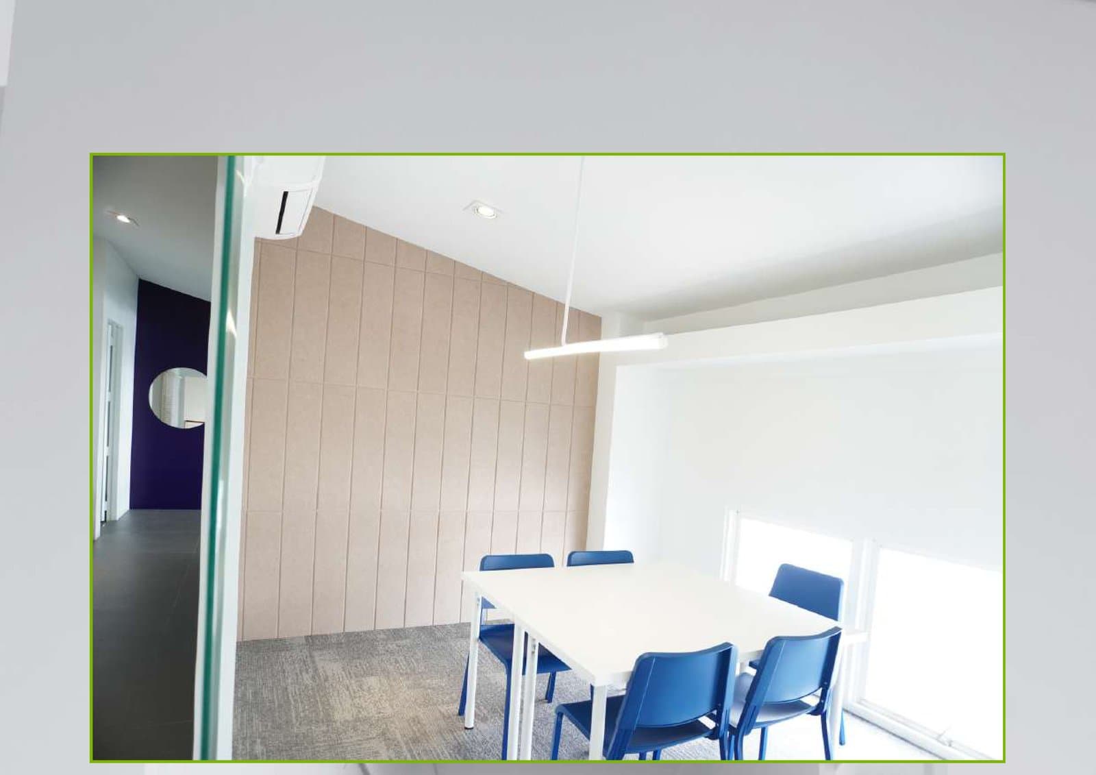 Private meeting room with acoustic wall panels and glass partition